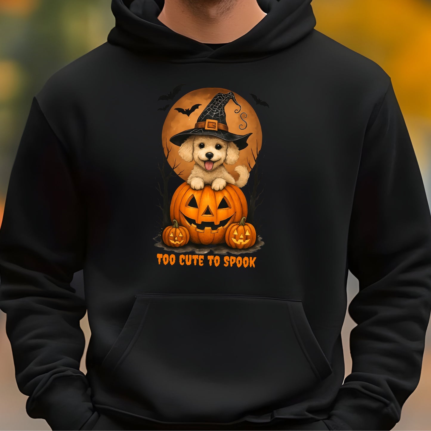 Black hoodie with a Halloween-themed design featuring a dog in a witch hat and pumpkins.