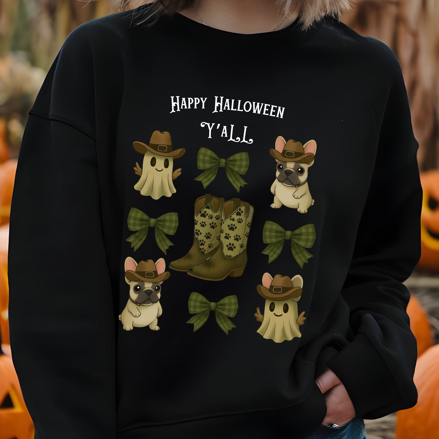 Black sweatshirt with Halloween-themed design featuring ghosts, boots, and bows, with pumpkins in the background.