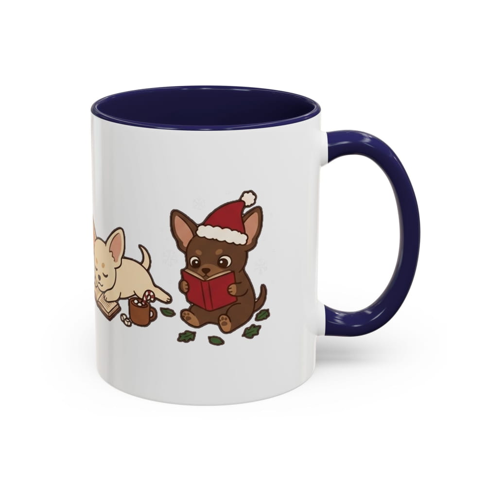 A white ceramic mug with a dark navy blue interior, handle, and rim, featuring a cute cartoon illustration of two chihuahuas on the side. One chihuahua is tan and drinking from a small brown mug, while the other is brown and wearing a red Santa hat and reading a red book.