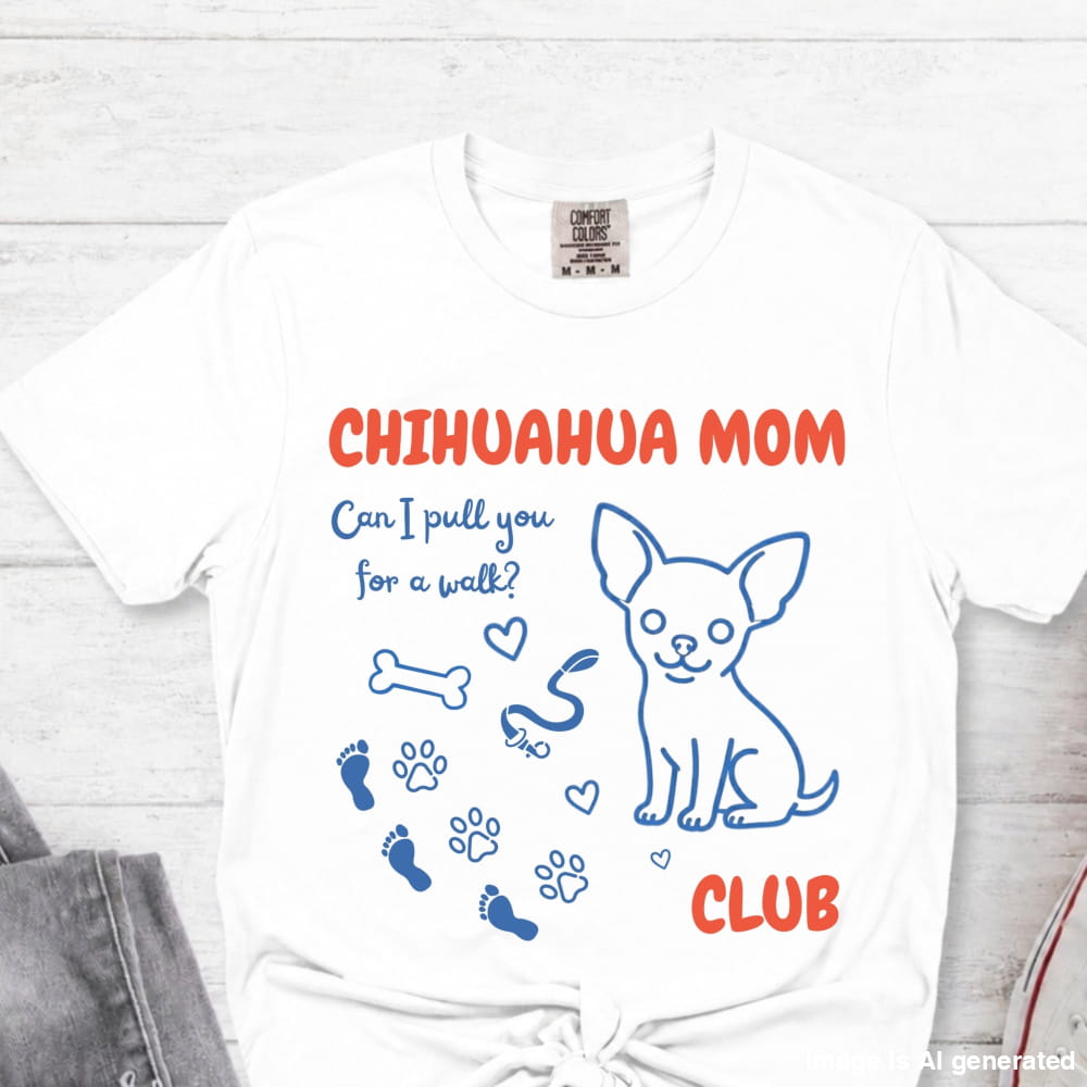 White t-shirt with 'Chihuahua Mom Club' text and graphics on a light wooden surface.