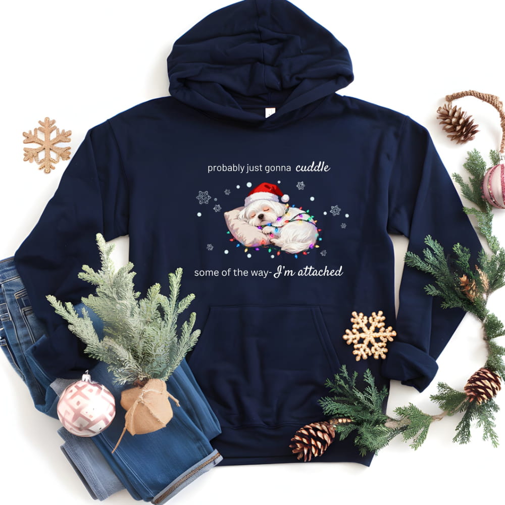 Navy blue hoodie with Christmas-themed design featuring a bear in a Santa hat and text, surrounded by holiday decorations on a white background.