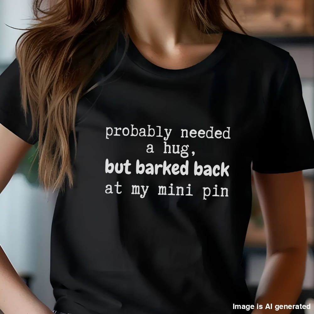 Black unisex t-shirt with white text: "probably needed a hug, but barked back at my mini pin" centered on the chest