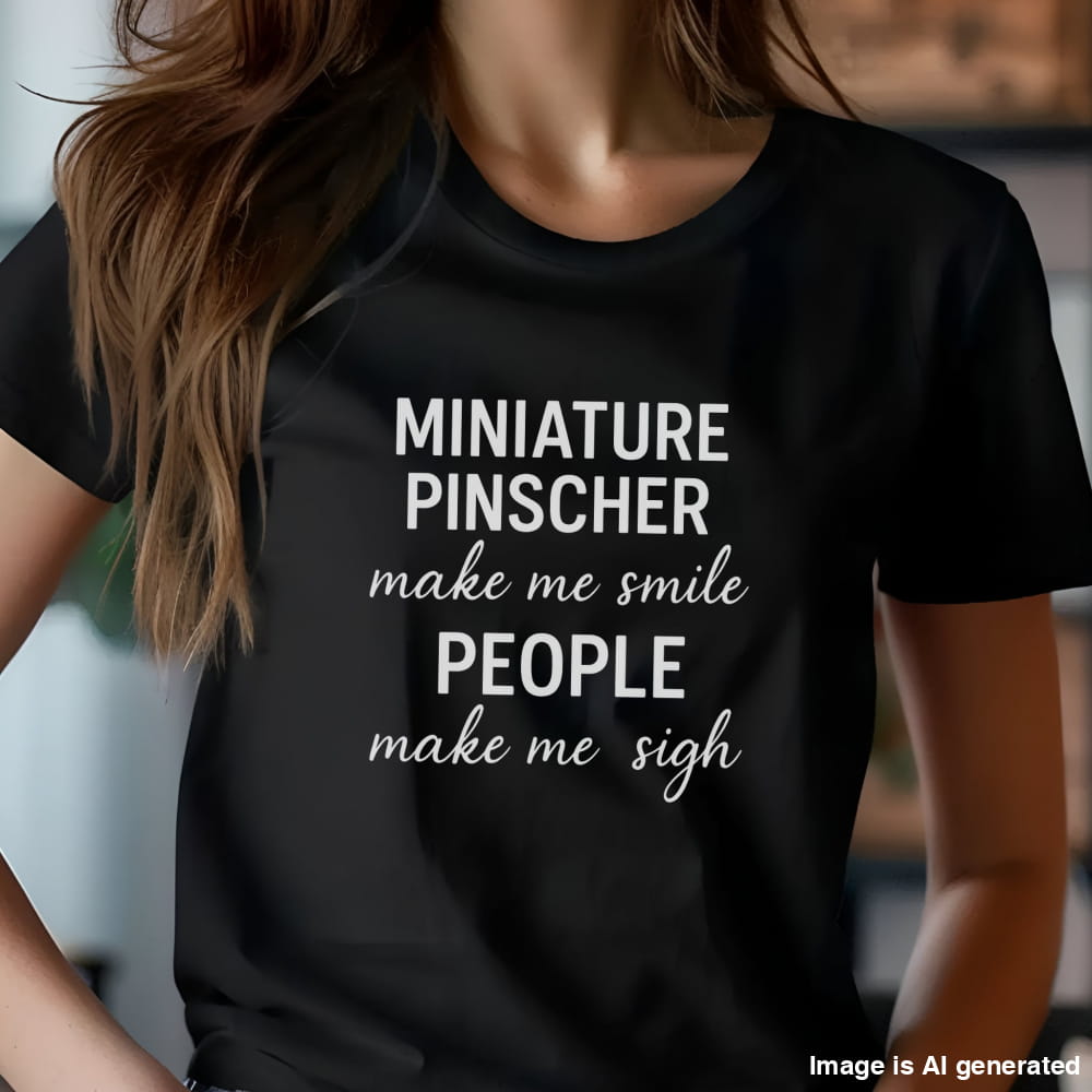 Woman wearing a black "Miniature Pinscher make me smile, people make me sigh" unisex t-shirt, casual kitchen background