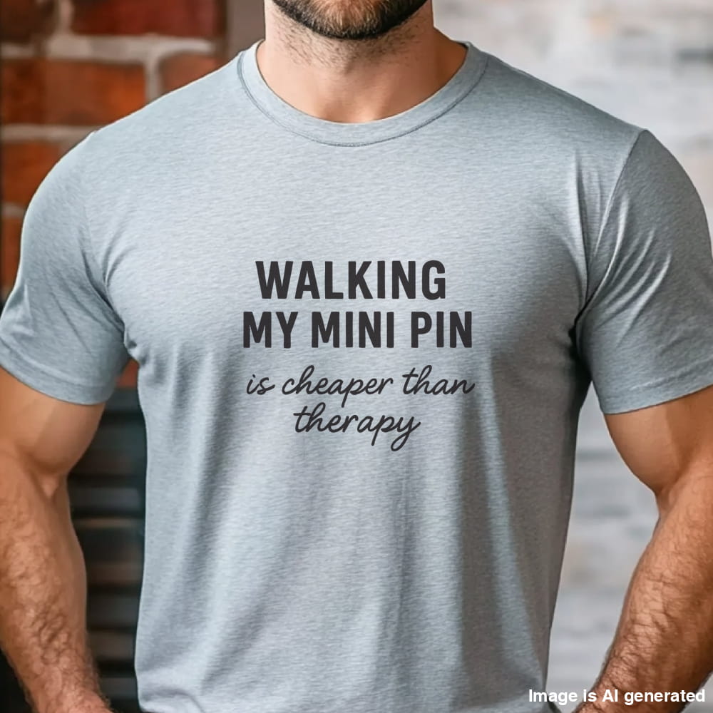 Grey unisex t-shirt with black text: "WALKING MY MINI PIN is cheaper than therapy" centered on chest