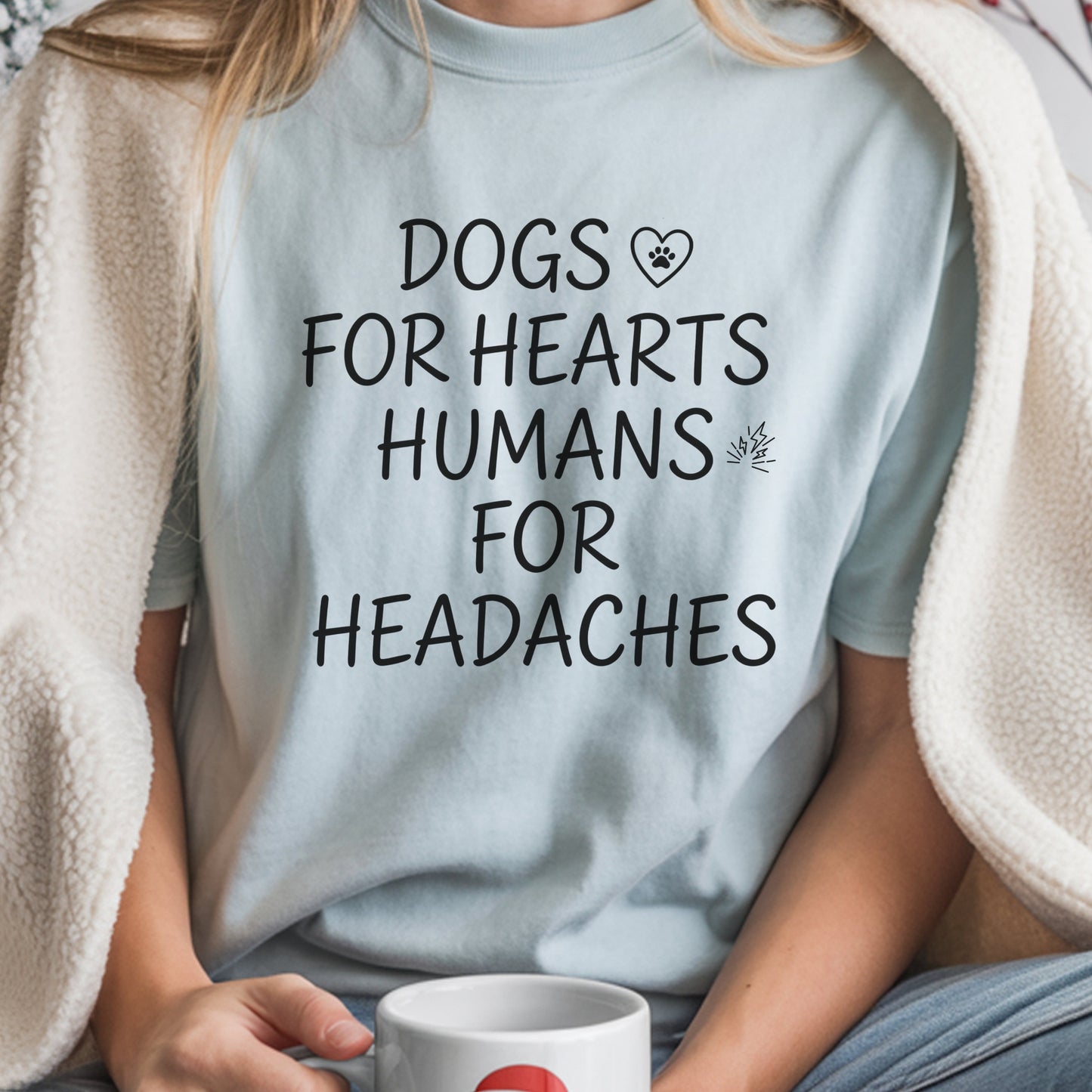 Person wearing a light blue t-shirt with a humorous text design, holding a mug.