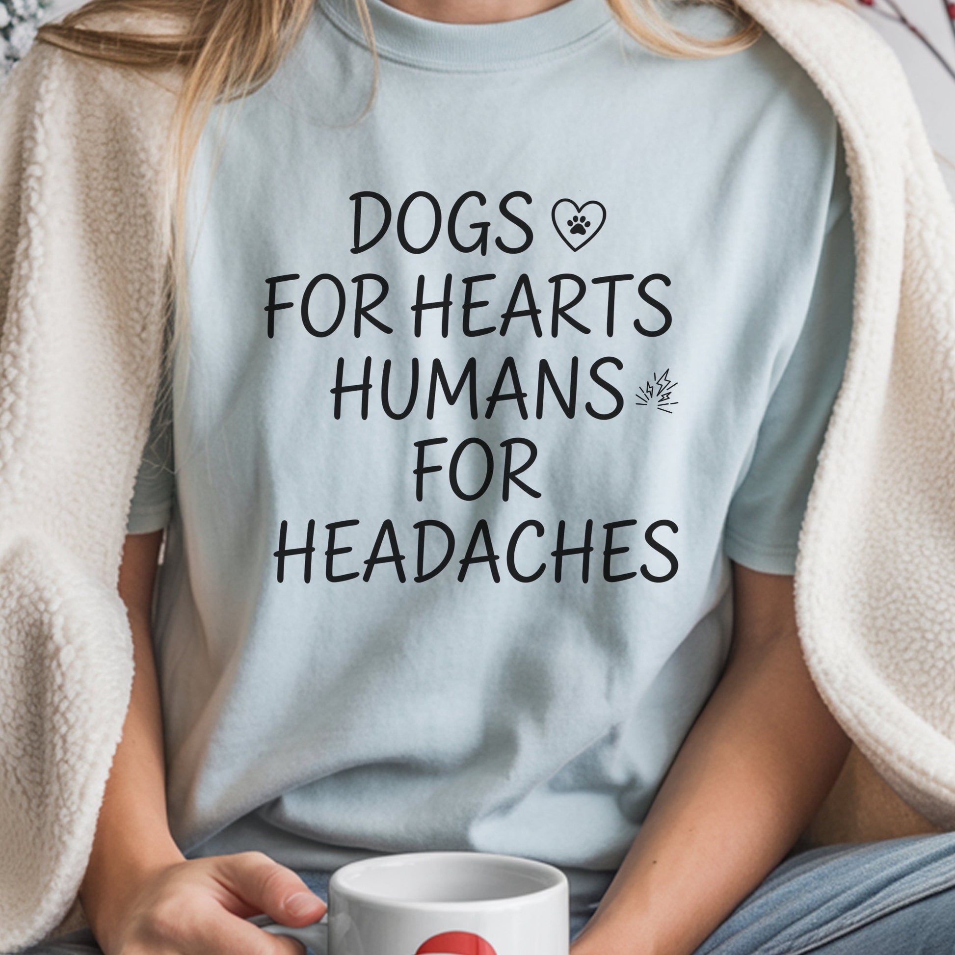 Person wearing a light blue t-shirt with a humorous text design, holding a mug.