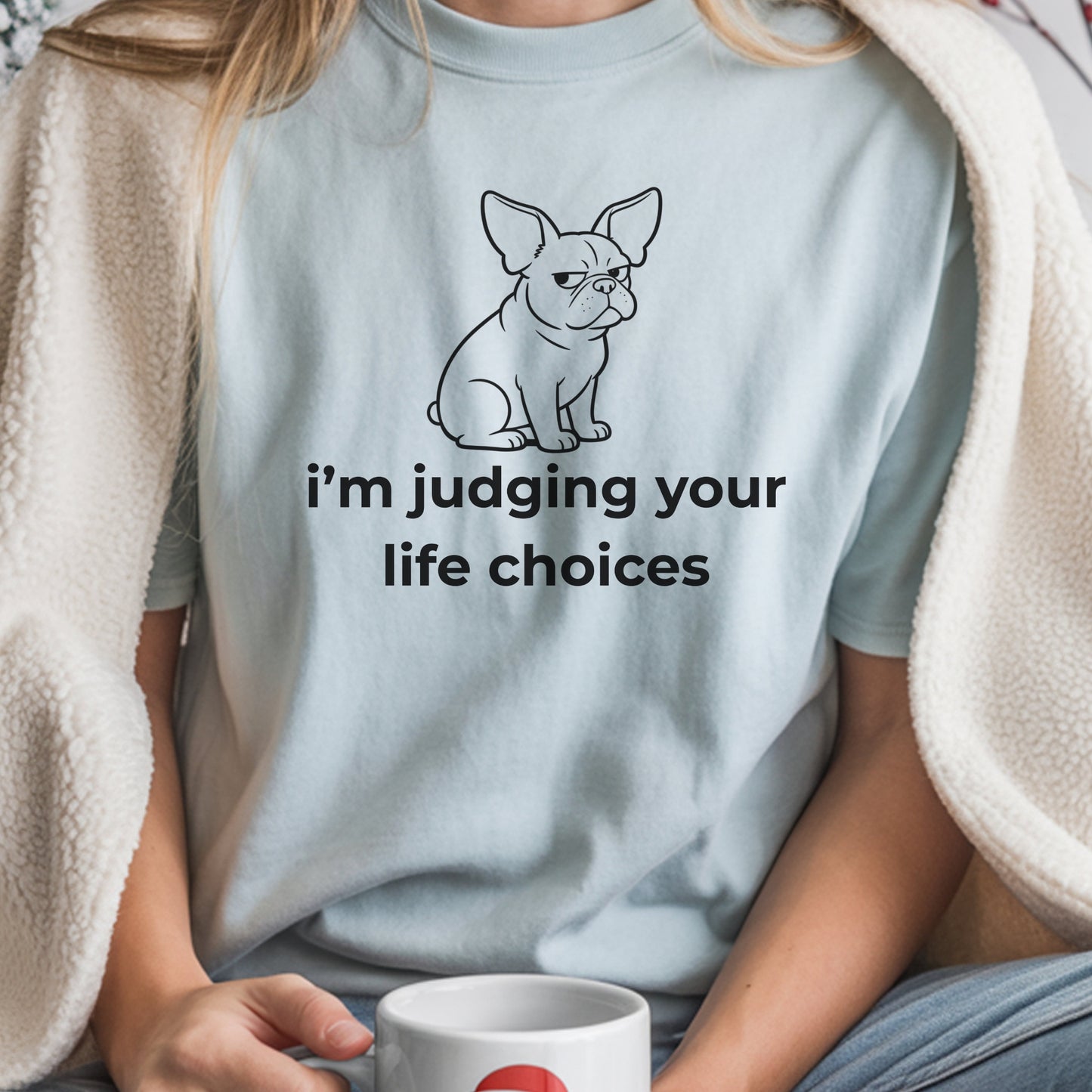 Person wearing a light blue t-shirt with a dog graphic and text, holding a mug.