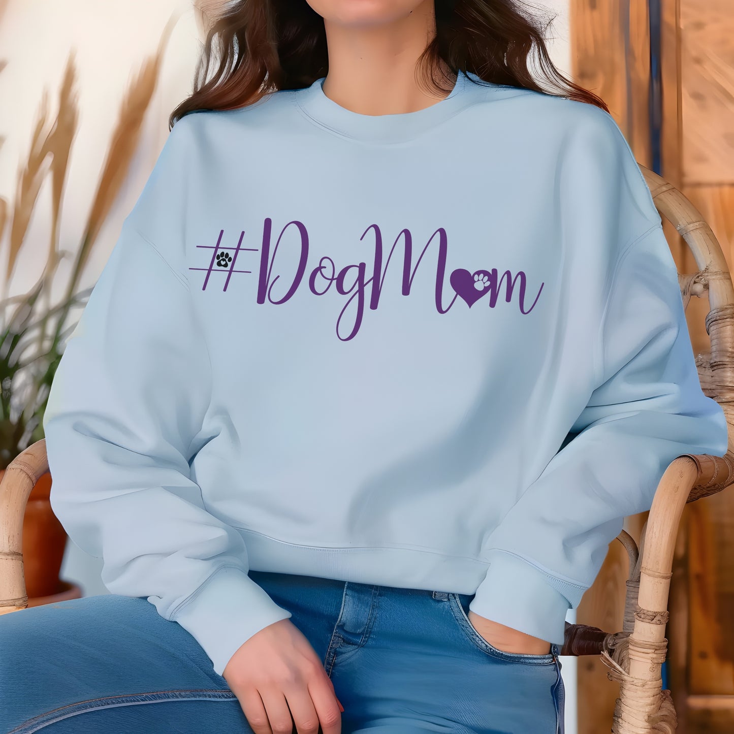 Person wearing a light blue sweatshirt with '#DogMom' printed in purple.