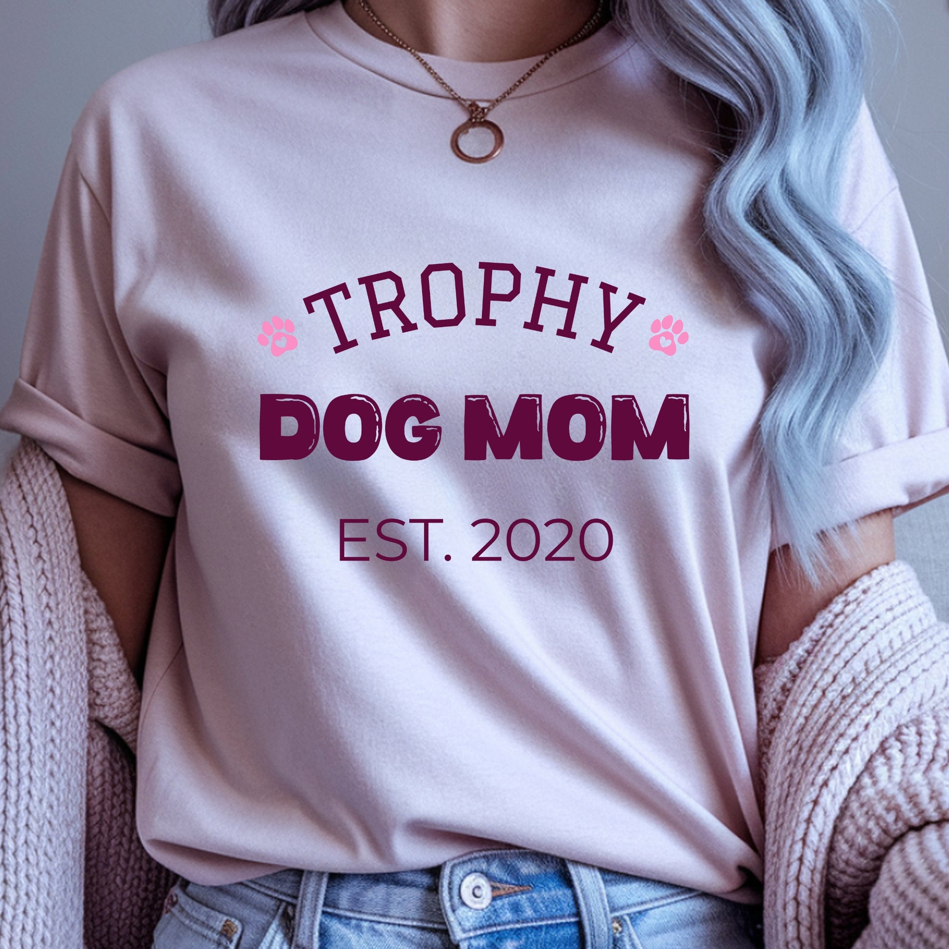 Person wearing a pink t-shirt with 'Trophy Dog Mom Est. 2020' text.