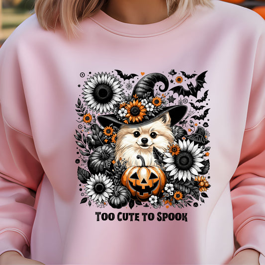 Pink sweatshirt with a Halloween-themed design featuring a dog in a witch hat and pumpkins.