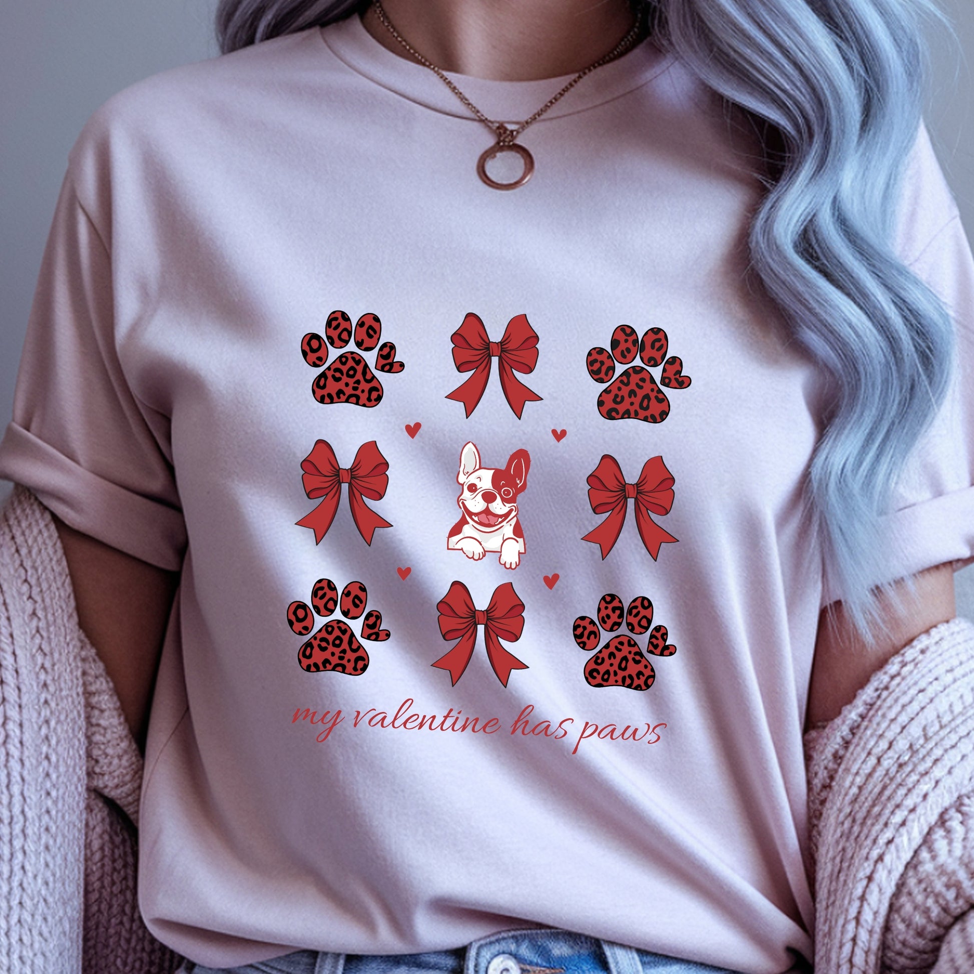 Person wearing a light pink t-shirt with Valentine's Day-themed graphics and text.