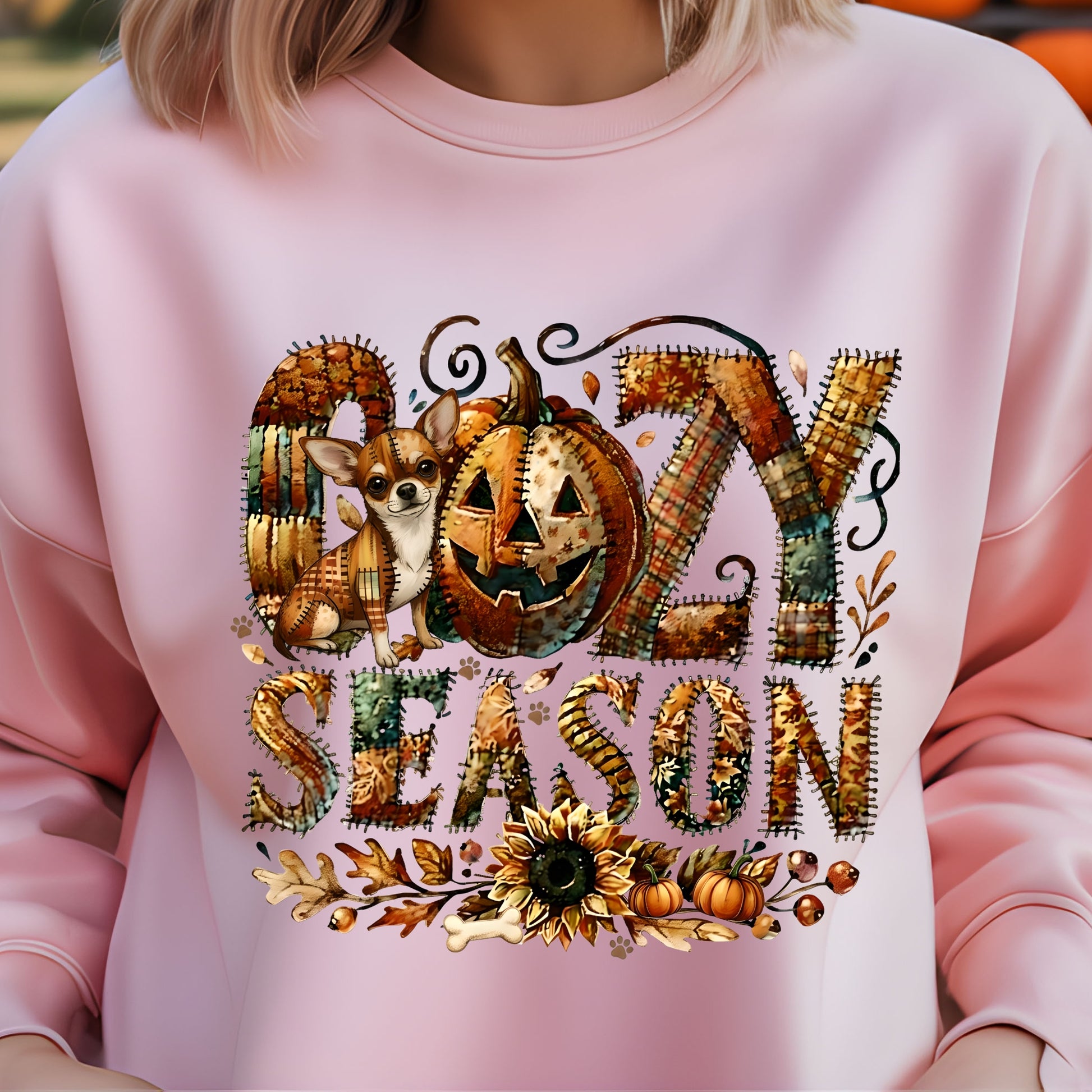 Cozy Season patchwork sweatshirt featuring a hidden Chihuahua in autumn colors, surrounded by pumpkins, leaves, and a sunflower.Cozy patchwork sweatshirt with "Cozy Season" text, autumn colors, pumpkins, sunflower, and a hidden Chihuahua motif.