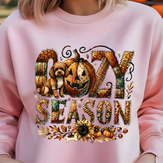 Pink sweatshirt with Halloween-themed design featuring pumpkins and text on a blurred background