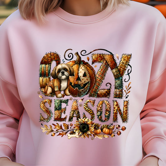 Pink sweatshirt with 'Ozzy Season' design featuring a pumpkin and dog, on a blurred background.