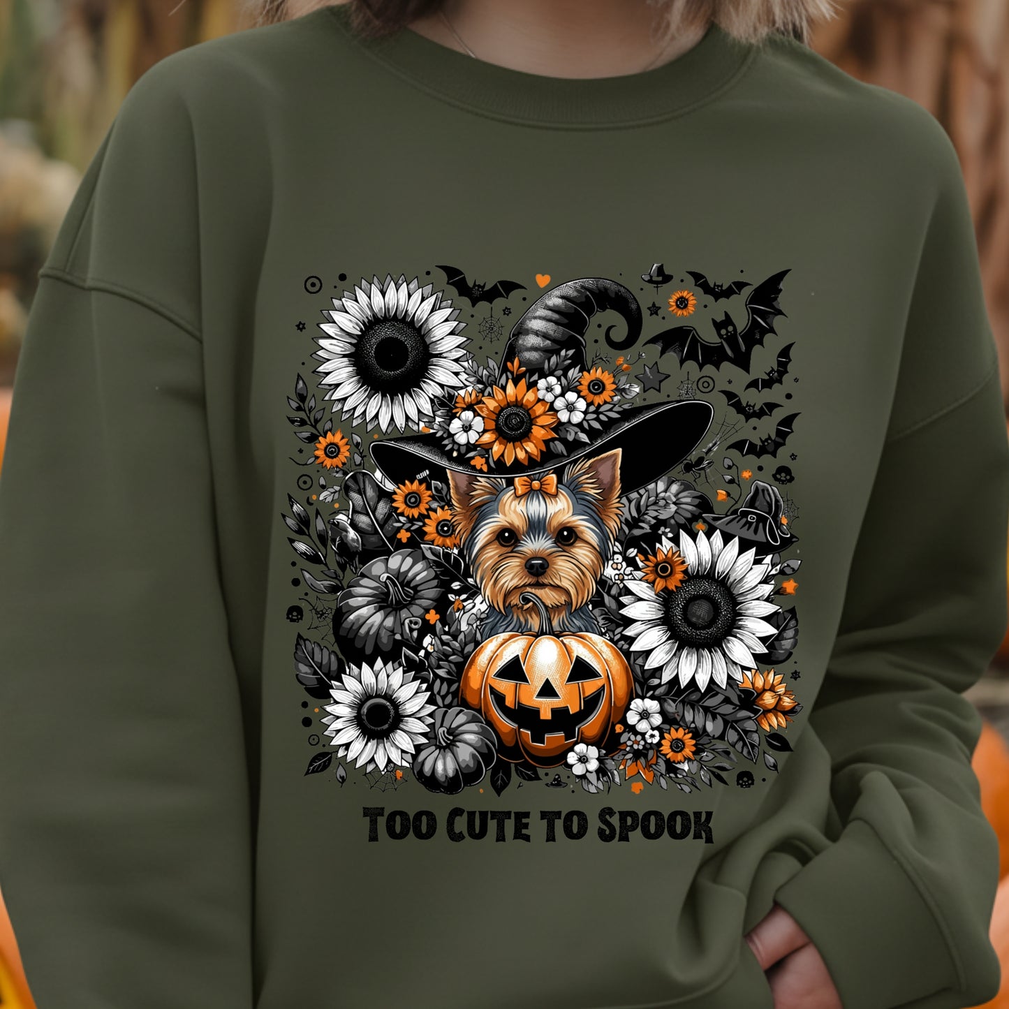 Green sweatshirt with a dog and Halloween-themed design on a blurred background