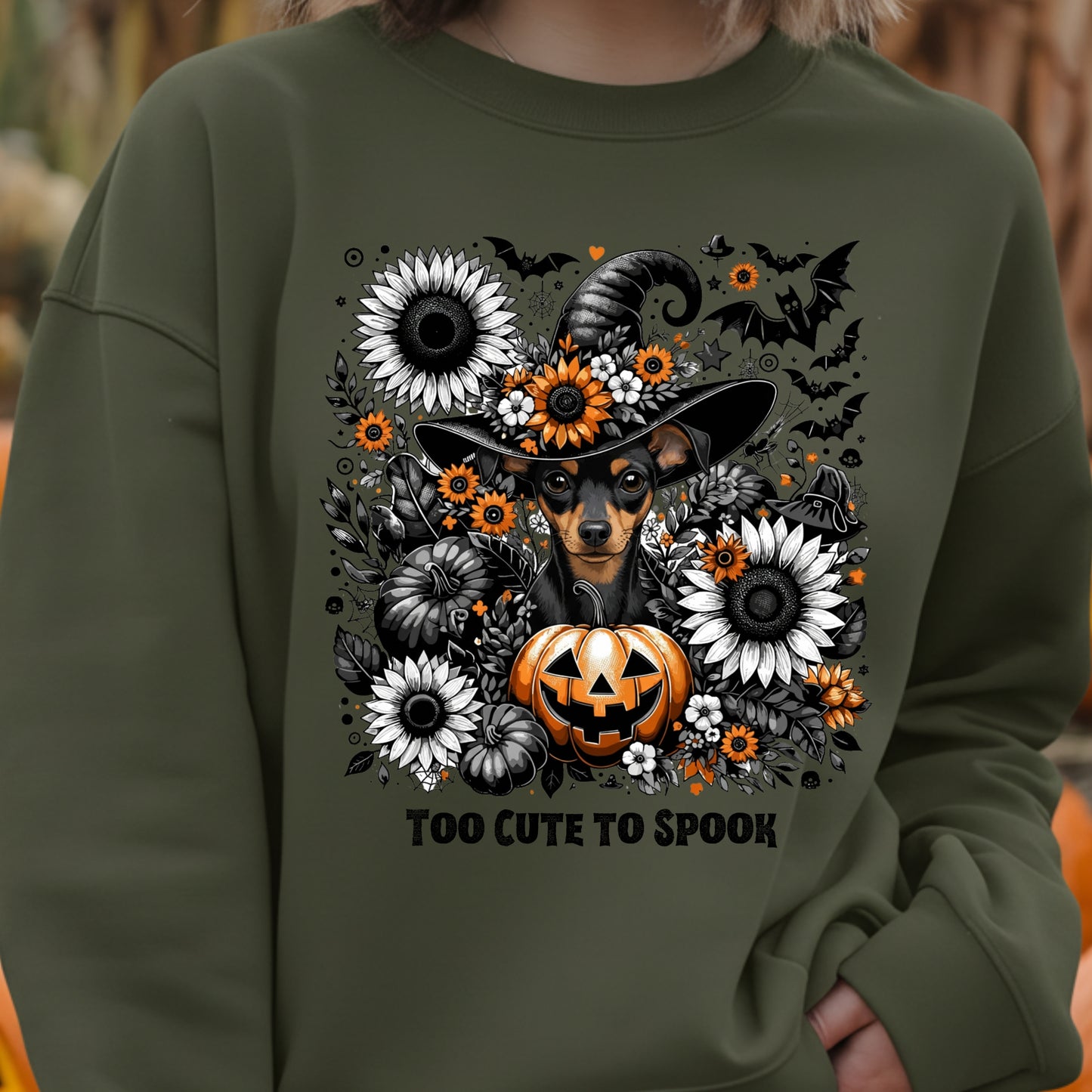 Green sweatshirt with Halloween-themed design featuring a dog, pumpkin, and flowers.