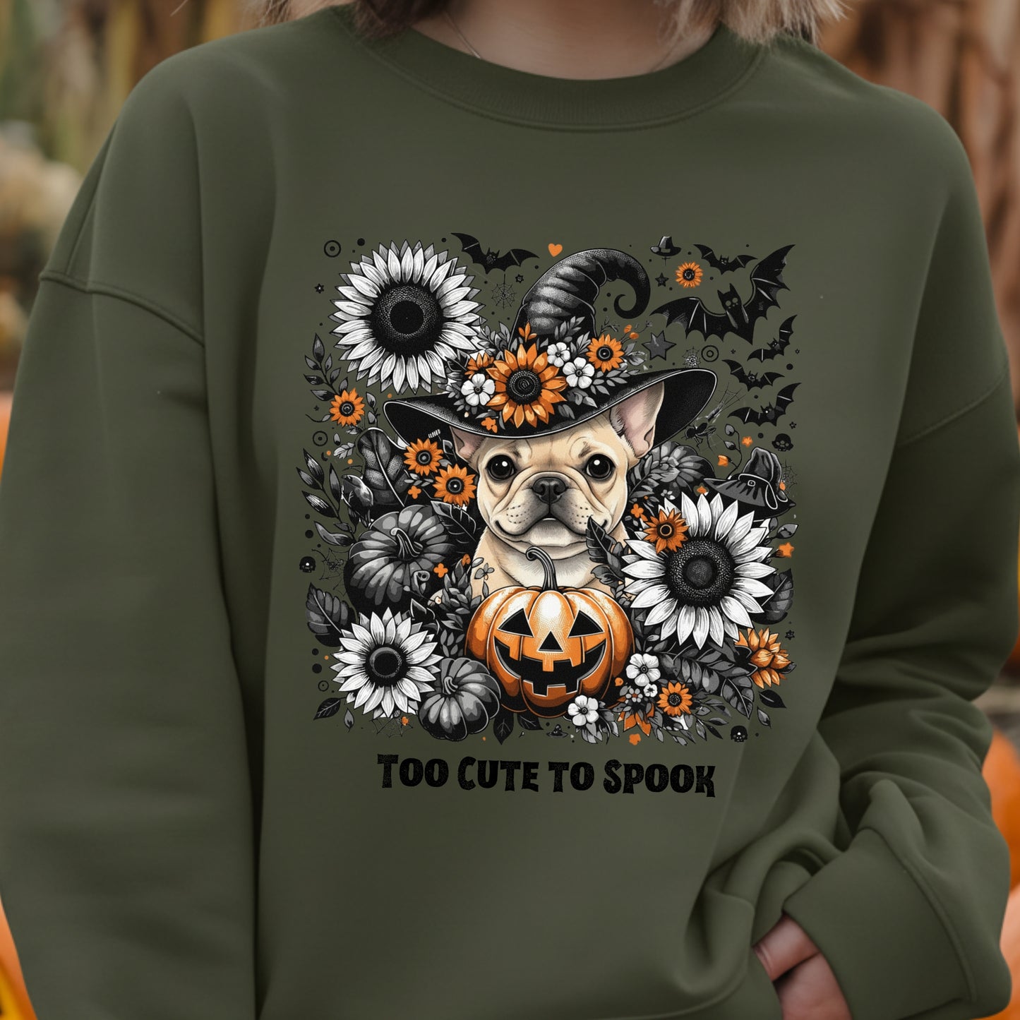Green sweatshirt with a Halloween-themed design featuring a dog in a witch hat and pumpkin, surrounded by flowers.