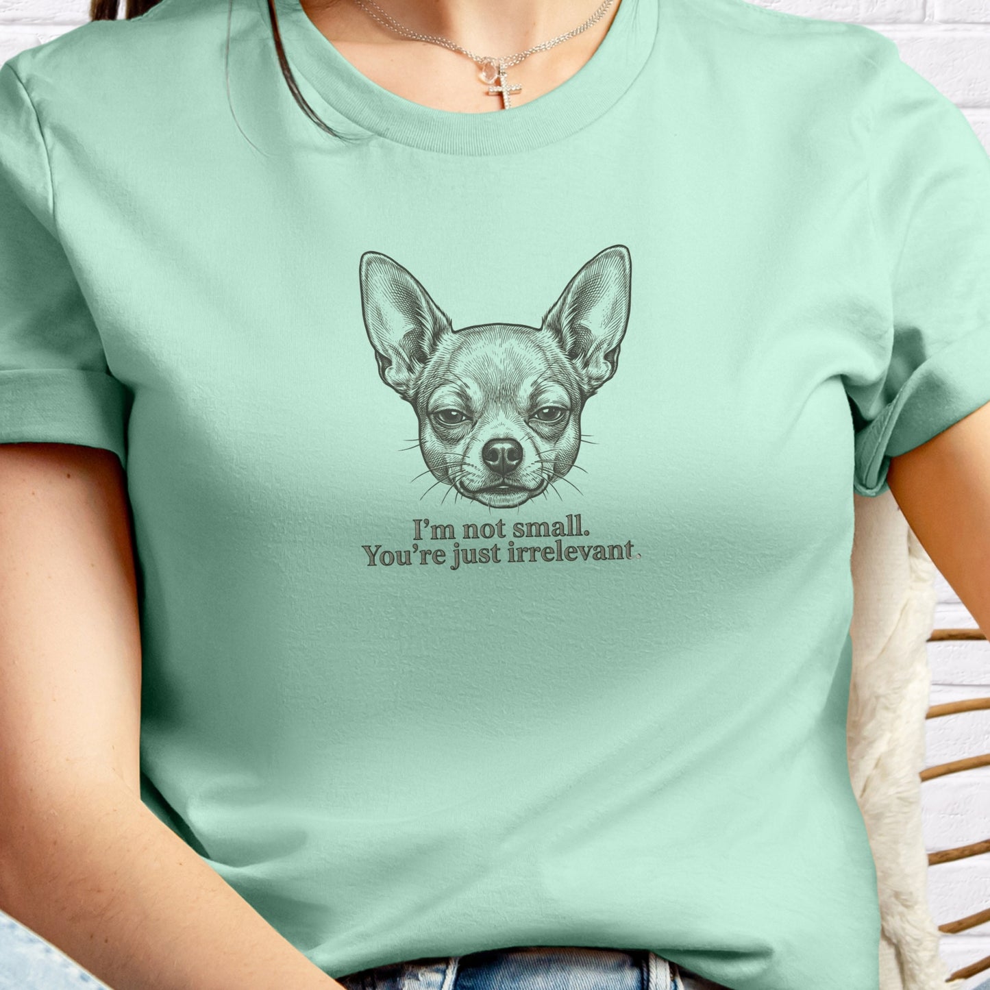 Person wearing a light green t-shirt with a dog illustration and text.