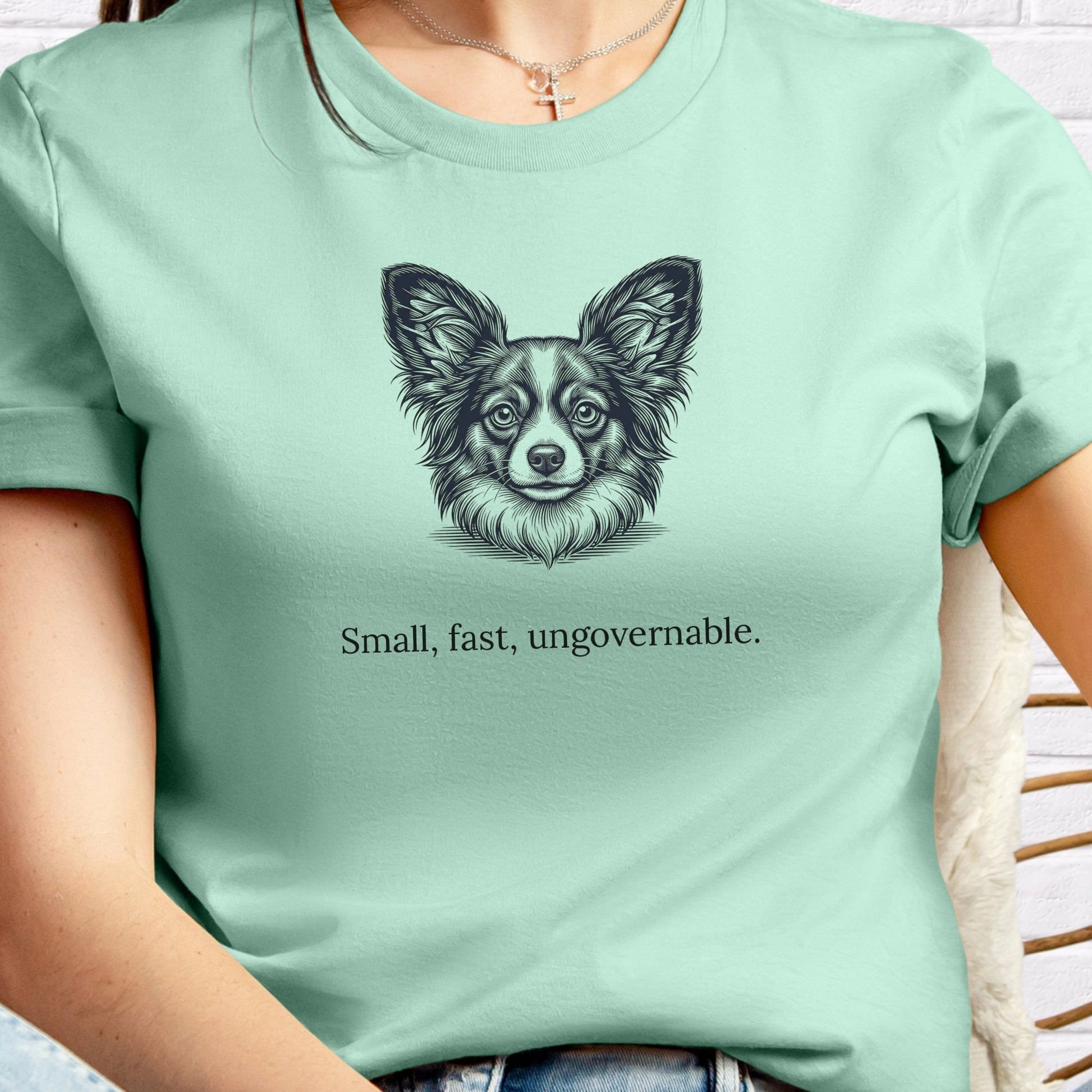 Person wearing a light green t-shirt with a dog illustration and text.