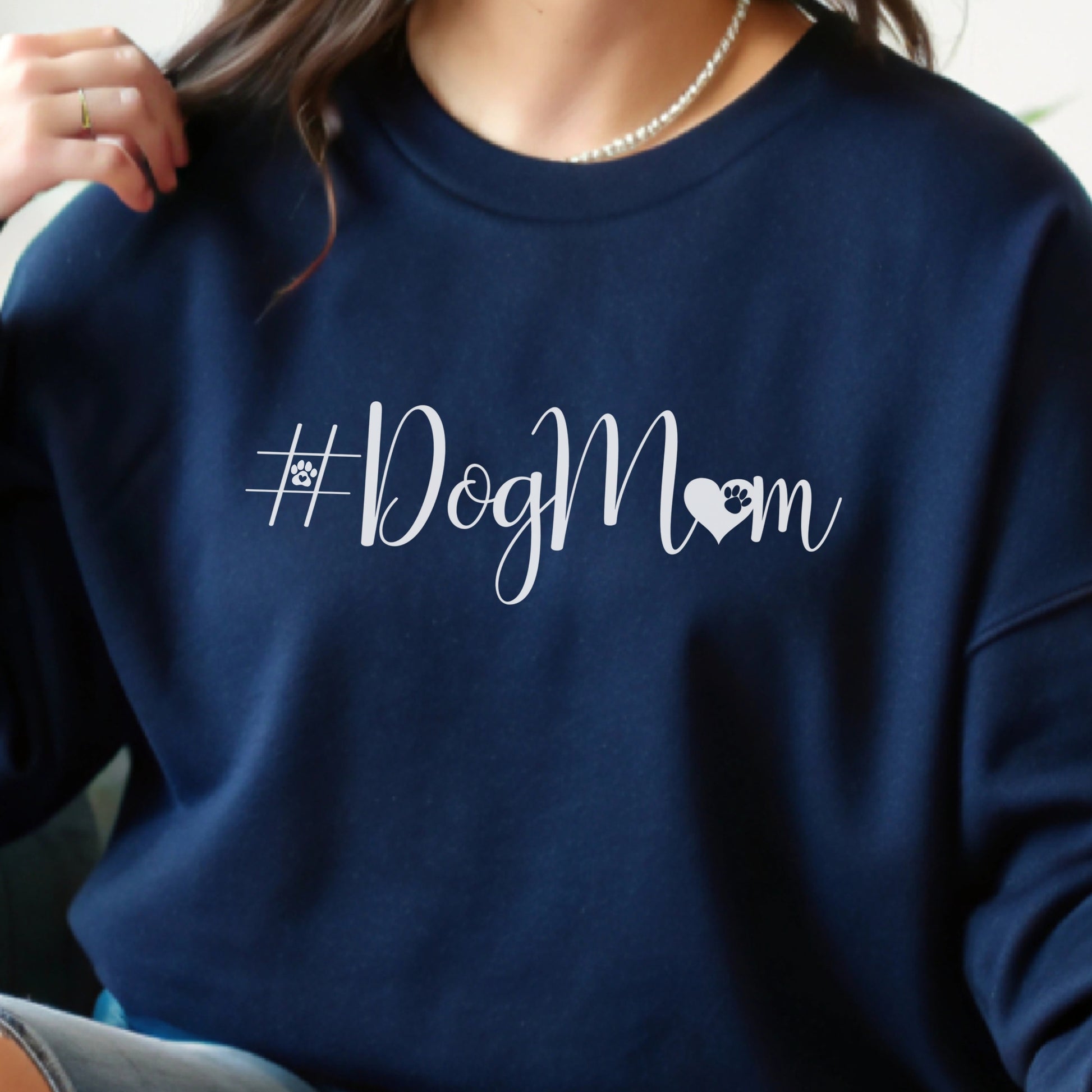 Navy blue sweatshirt with '#DogMom' text on a person wearing it.