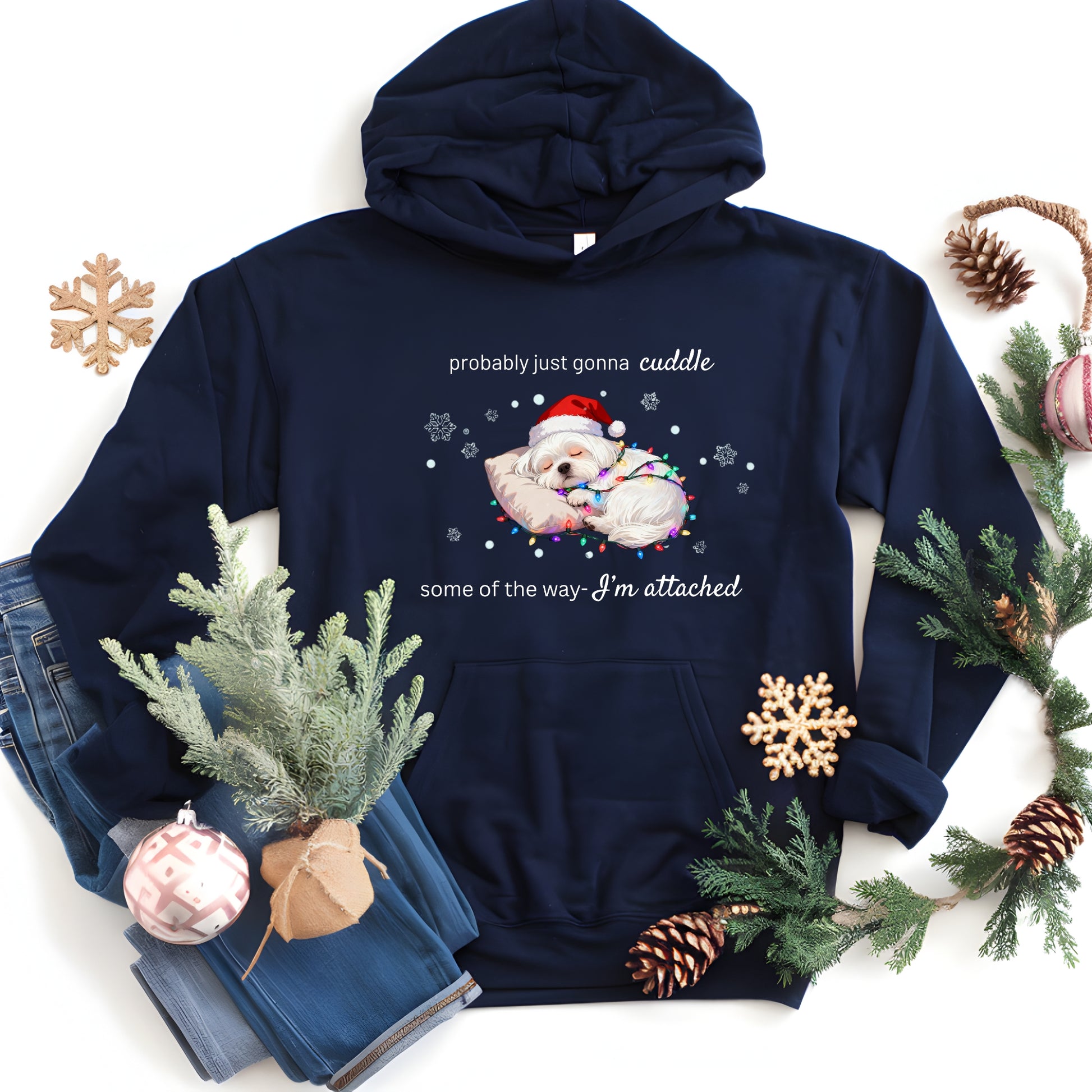 Navy blue hoodie with Christmas-themed design featuring a bear in a Santa hat and text, surrounded by holiday decorations on a white background.