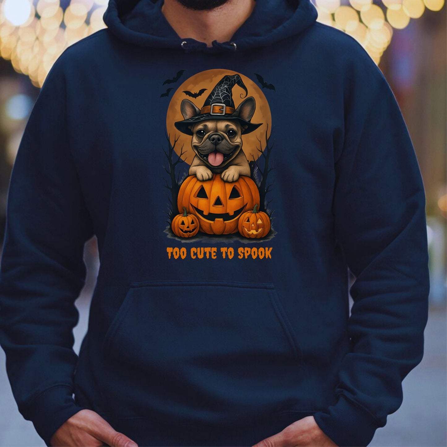 French Bulldog wearing a witch hat with pumpkins and bats, Halloween theme on a navy hoodie.