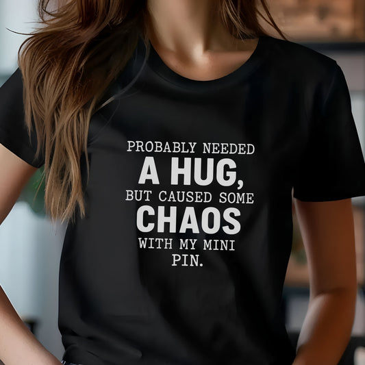 Black unisex t-shirt with white text: "Probably needed a hug, but caused some chaos with my Mini Pin." centered on the chest