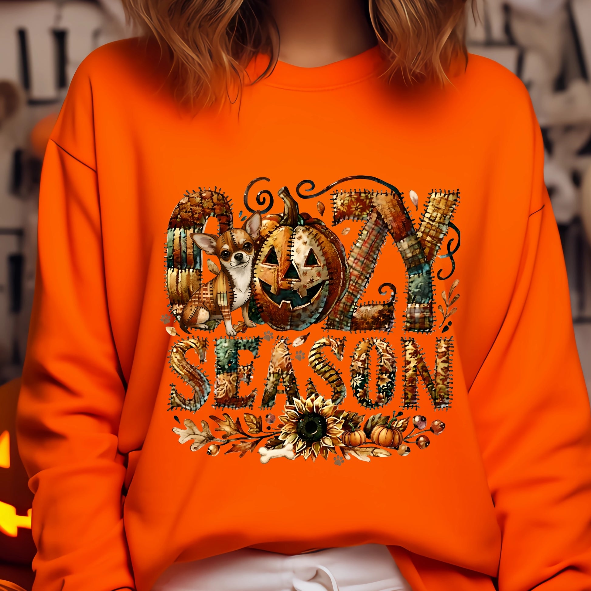 Cozy Season patchwork sweatshirt featuring a hidden Chihuahua in autumn colors, surrounded by pumpkins, leaves, and a sunflower.Cozy patchwork sweatshirt with "Cozy Season" text, autumn colors, pumpkins, sunflower, and a hidden Chihuahua motif.