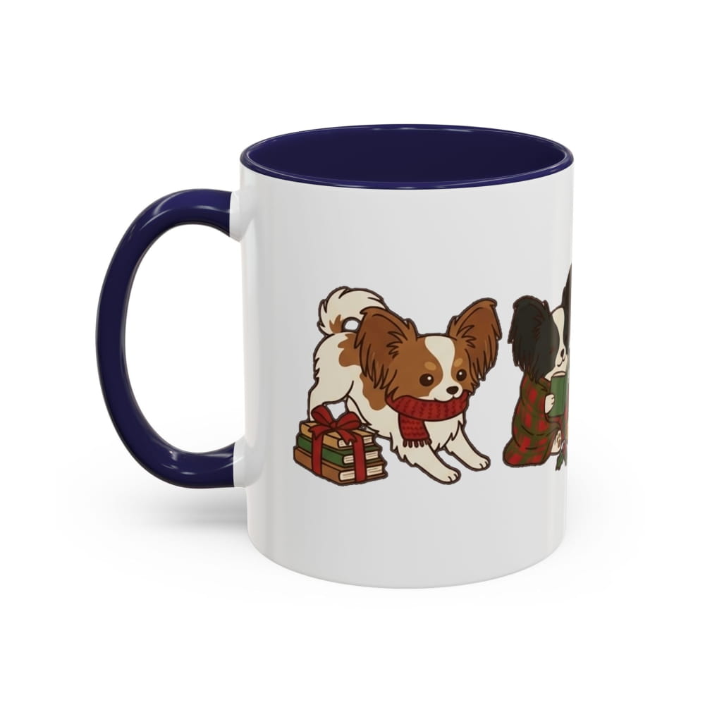 White ceramic mug with a navy interior and navy handle, showing a Papillon in a red scarf beside a wrapped gift and another Papillon in a plaid blanket.