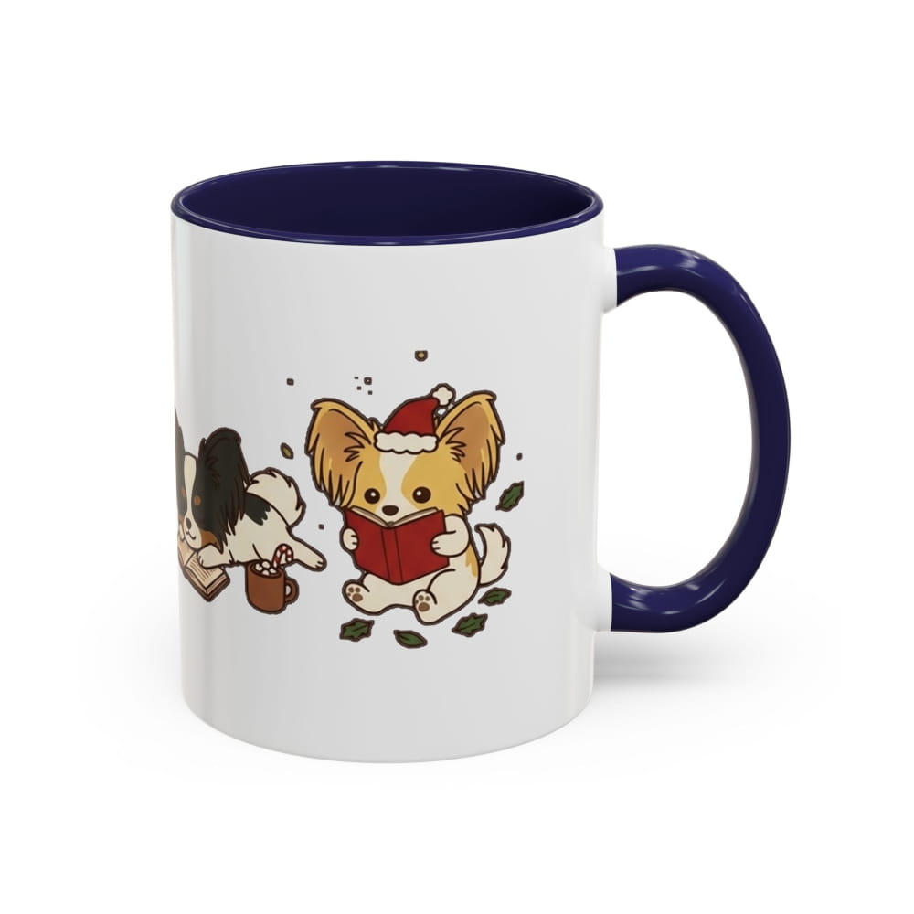 White ceramic mug with a navy interior and navy handle, showing a Papillon in a Santa hat reading a red book, with another Papillon beside it.