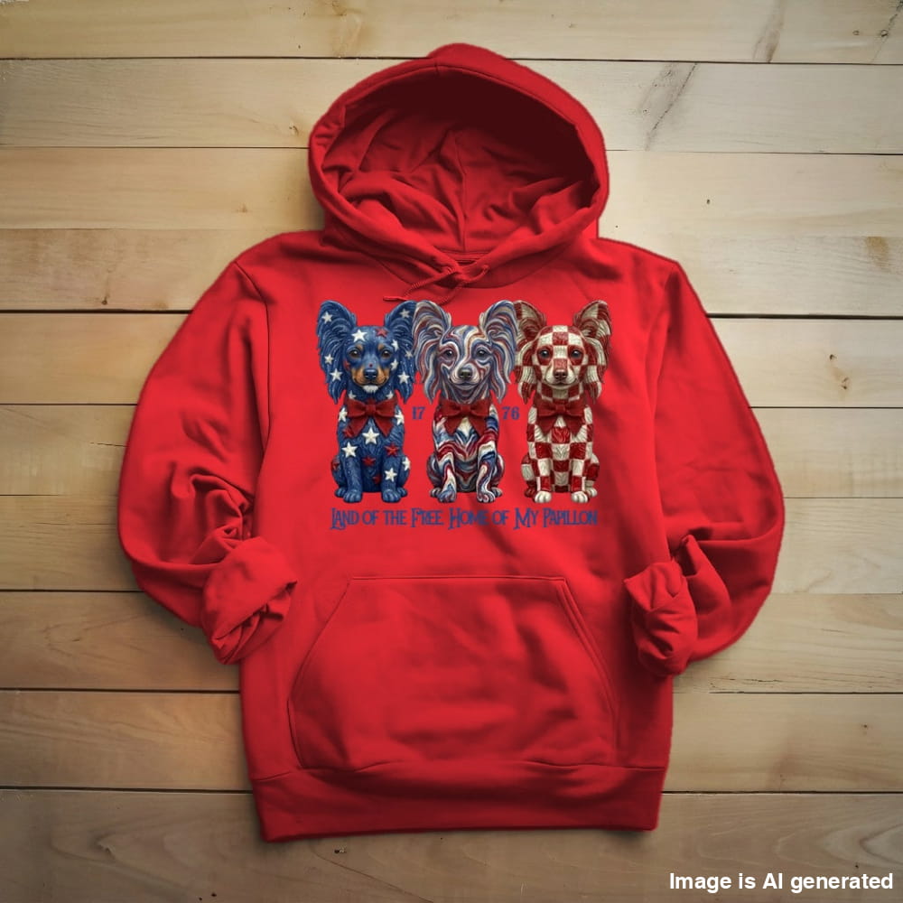 A red pullover hoodie laid flat on a light wood plank background, featuring a graphic of three Chihuahua dogs decorated with the American flag pattern and the text 'I love the Free People Who Wear It' printed below.