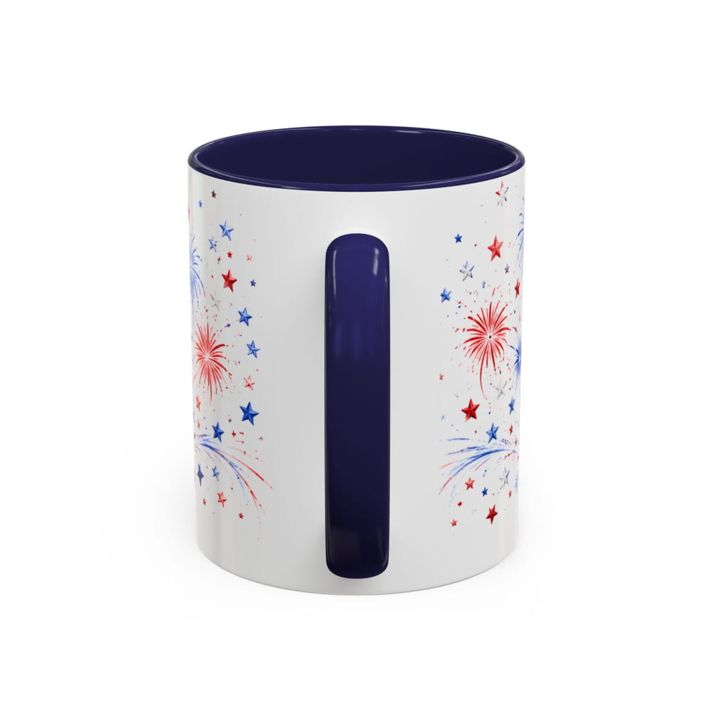 White mug with blue interior and handle, featuring red and blue star and firework designs on a white background.