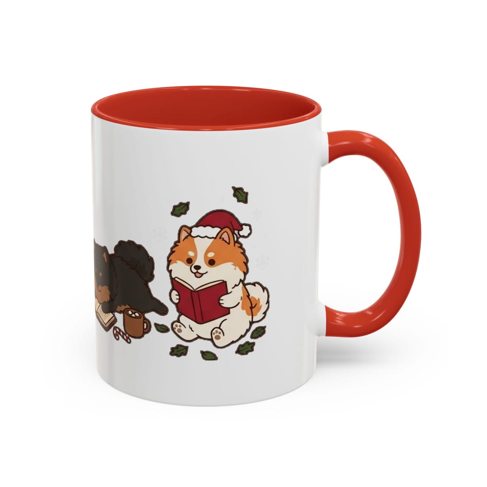 White ceramic mug with a red interior and red handle, showing an orange Pomeranian in a Santa hat reading a red book, with a black Pomeranian beside it.