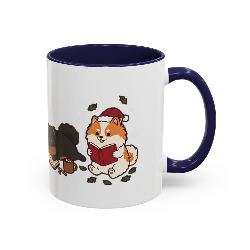 White ceramic mug with a navy interior and navy handle, showing an orange Pomeranian in a Santa hat reading a red book, with a black Pomeranian beside it.