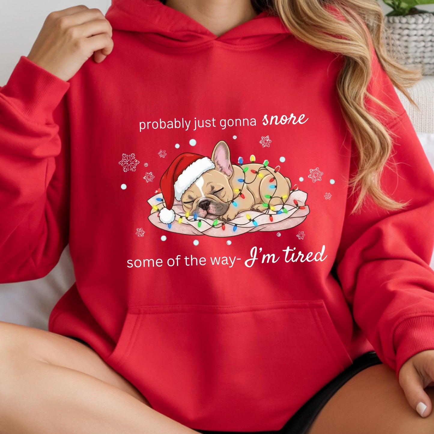 Red hoodie with a Christmas-themed design of a dog and text, held by a person.
