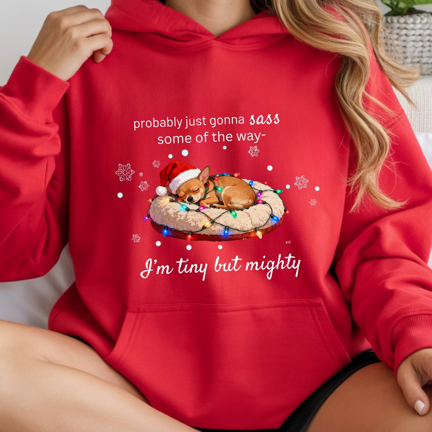 Red hoodie with a Christmas-themed design and text, worn by a person.