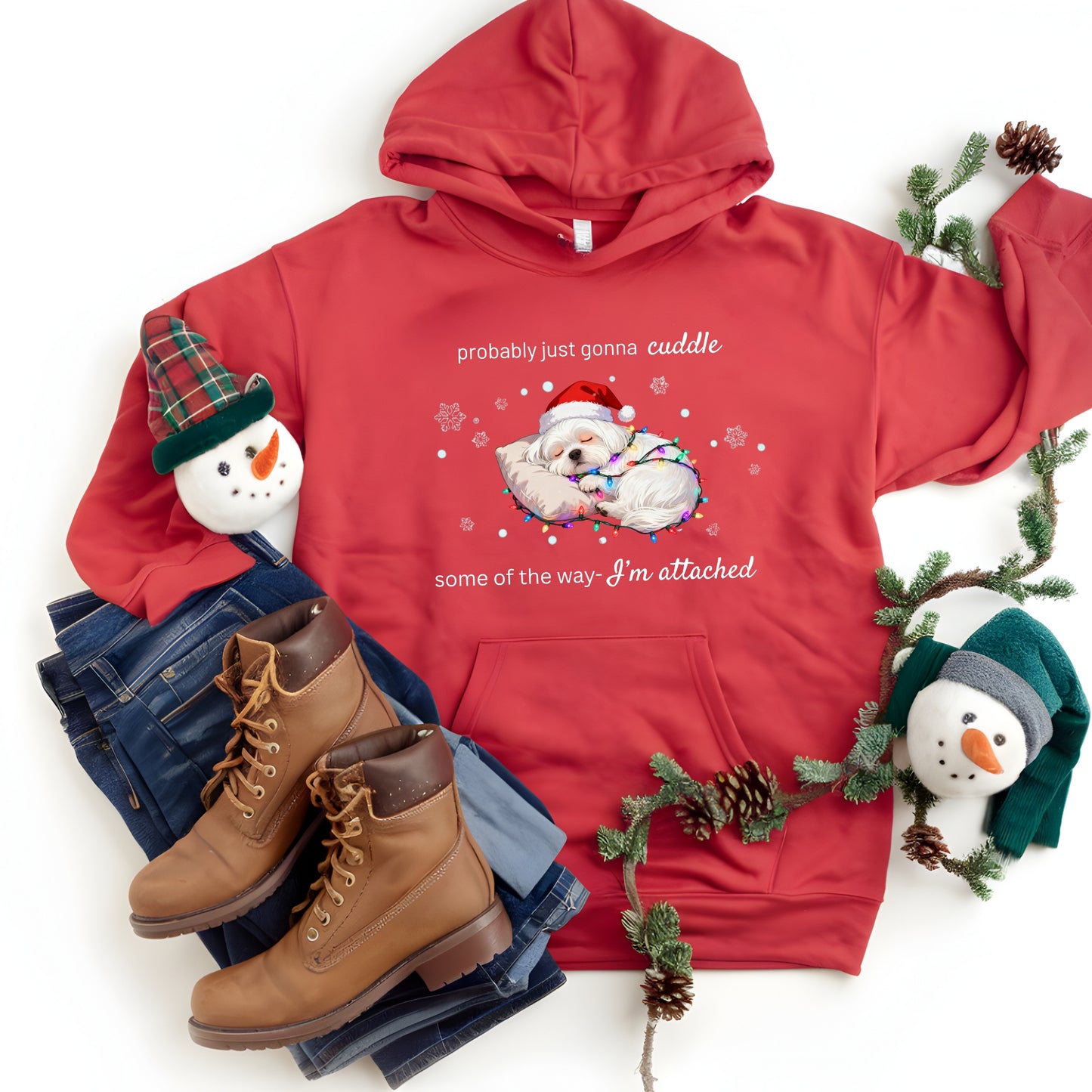 Red hoodie with Christmas-themed design, snowmen, and boots on a white background