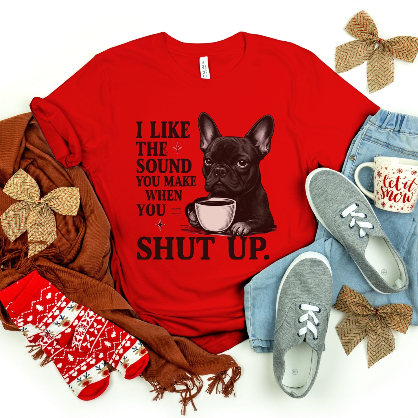 Red t-shirt with a dog graphic and text, surrounded by accessories on a white background