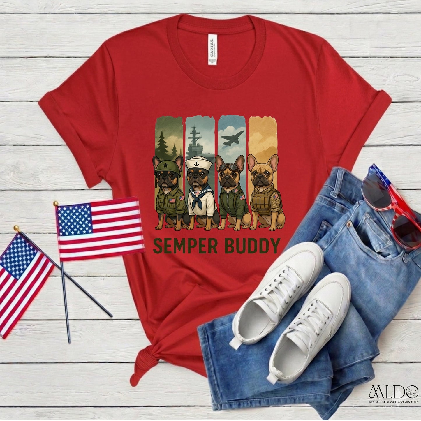 Red t-shirt with dog graphic and 'Semper Buddy' text, paired with jeans, sneakers, and American flags on a wooden surface.