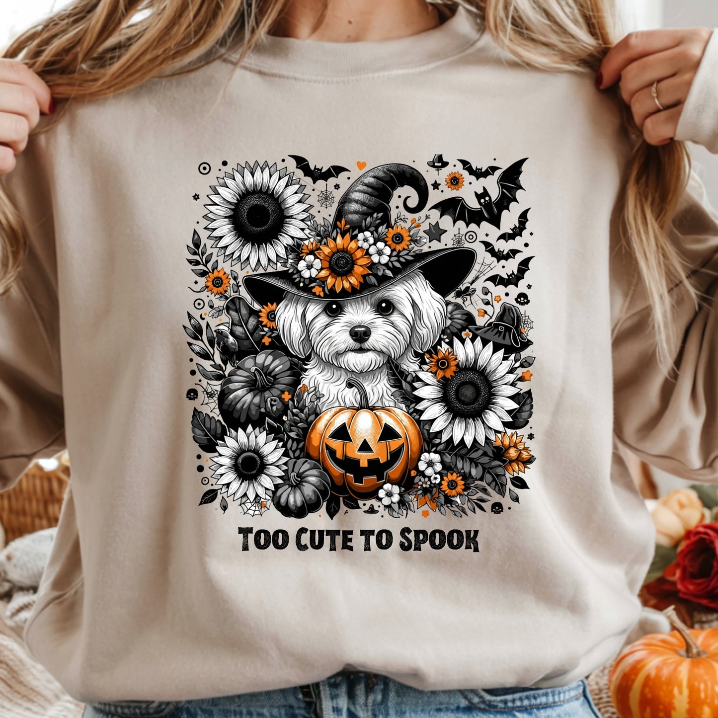 Beige sweatshirt with a Halloween-themed design featuring a dog in a witch hat and pumpkins.
