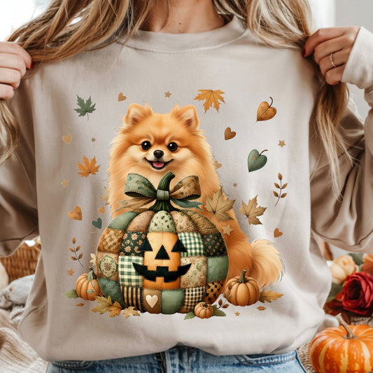 Person wearing a beige sweatshirt with a Pomeranian dog in a pumpkin patch design.