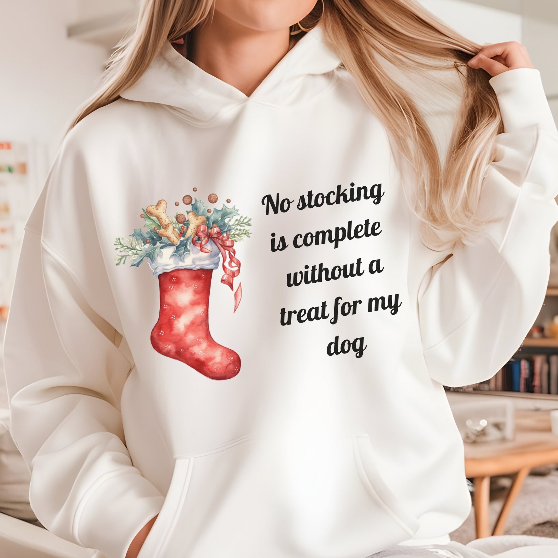 White hoodie with Christmas stocking design and text, worn by a person.