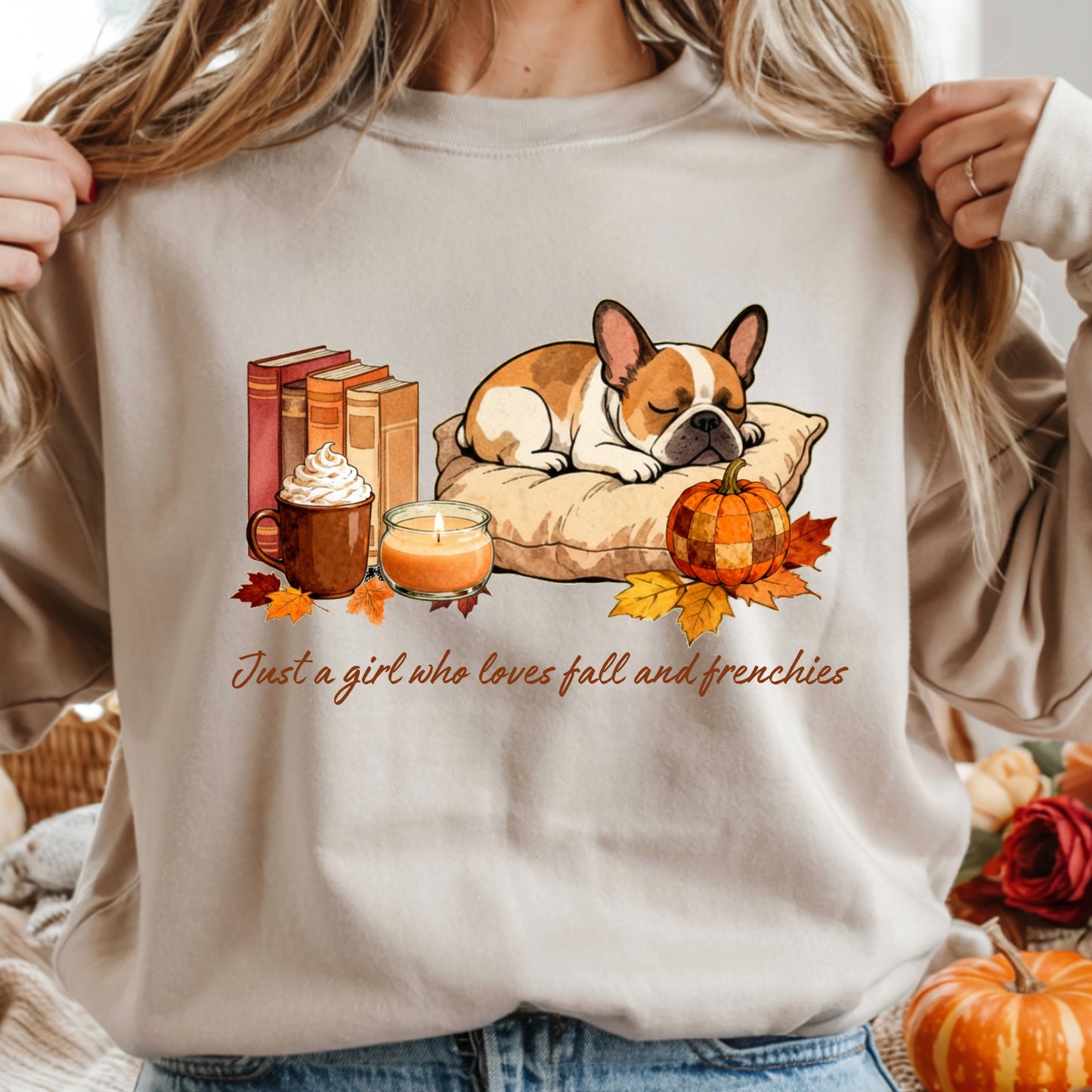 Beige sweatshirt with a design of a dog, pumpkin, and fall elements, held by a person.