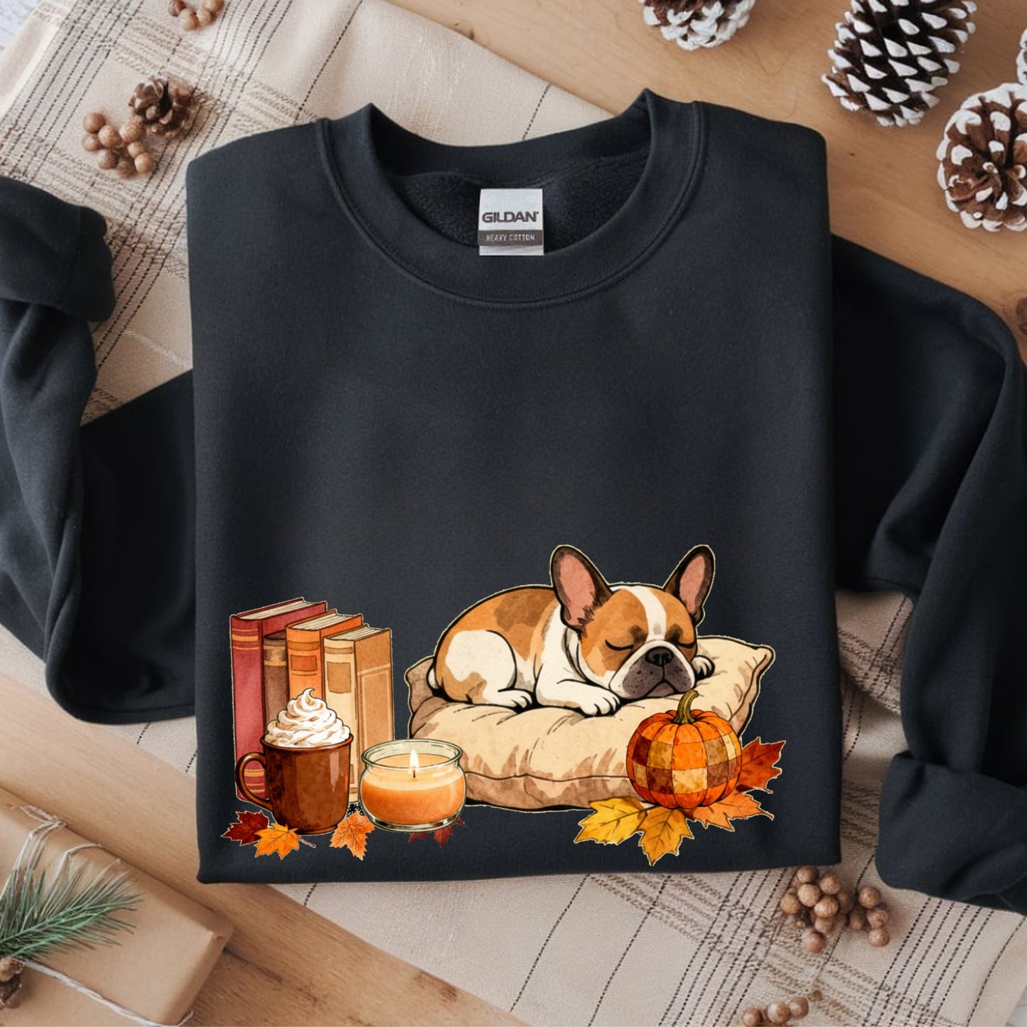 Black sweatshirt with a dog and autumn-themed design on a wooden surface.