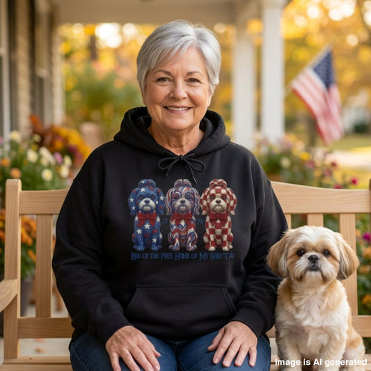 Woman in a black Land of the Free hoodie with three patriotic Shih Tzus, sitting on a bench next to her Shih Tzu