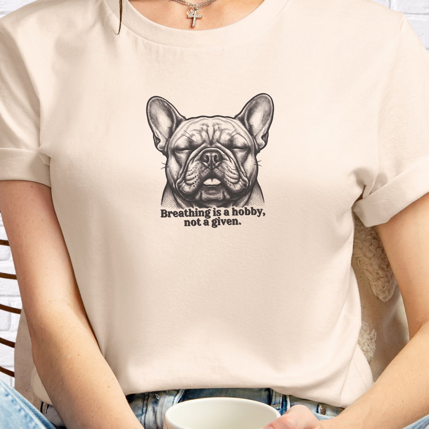 Beige t-shirt with a graphic of a dog and text, worn by a person.