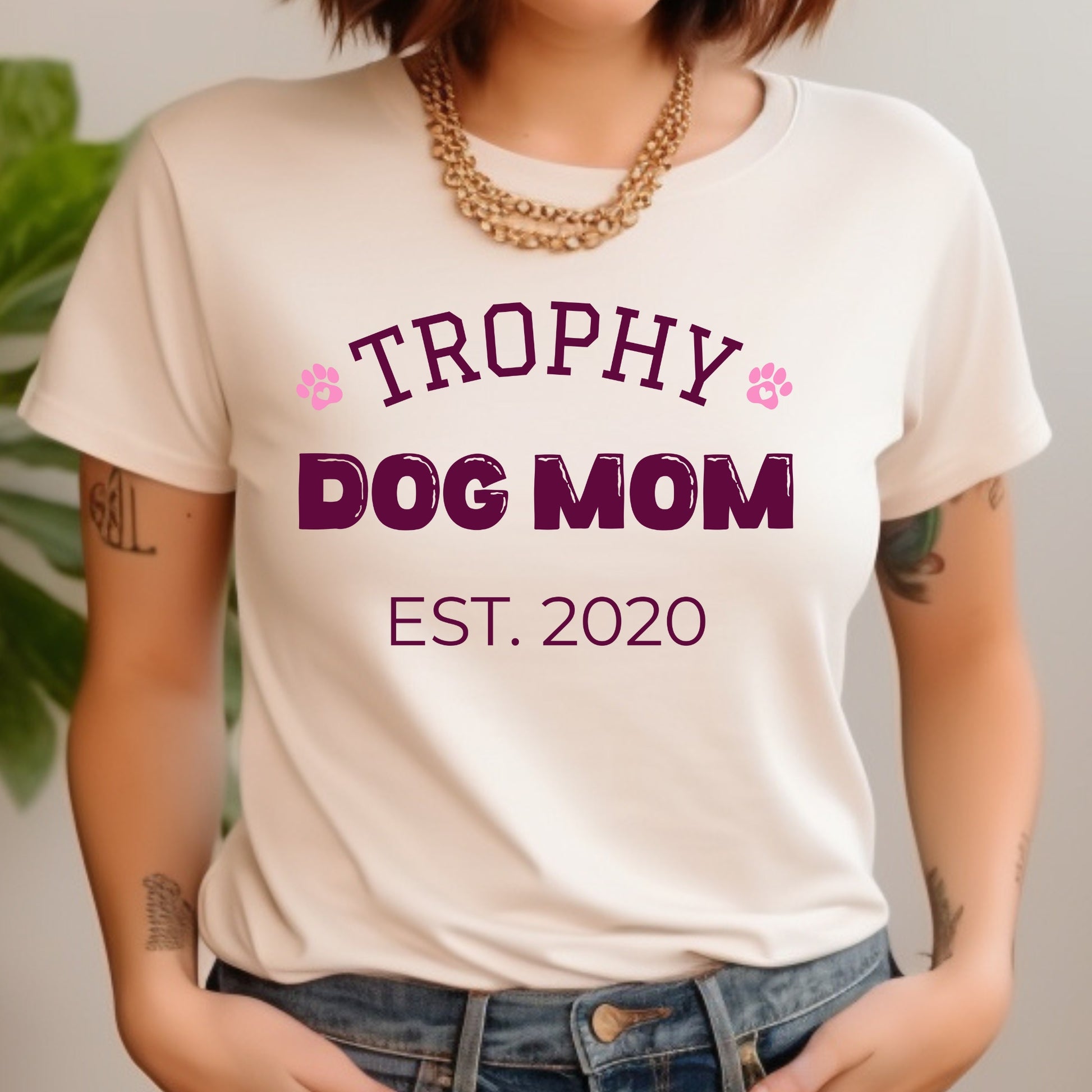 Person wearing a white t-shirt with 'Trophy Dog Mom Est. 2020' text.