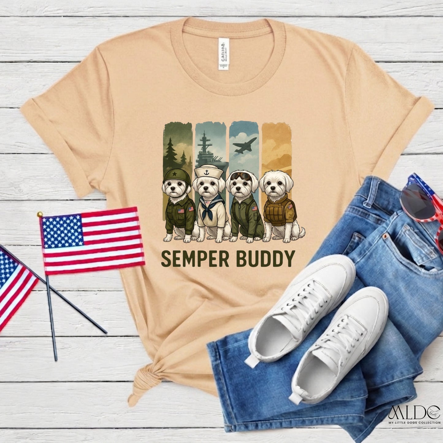 Beige t-shirt with 'Semper Buddy' graphic, American flags, white sneakers, and blue jeans on a wooden surface.