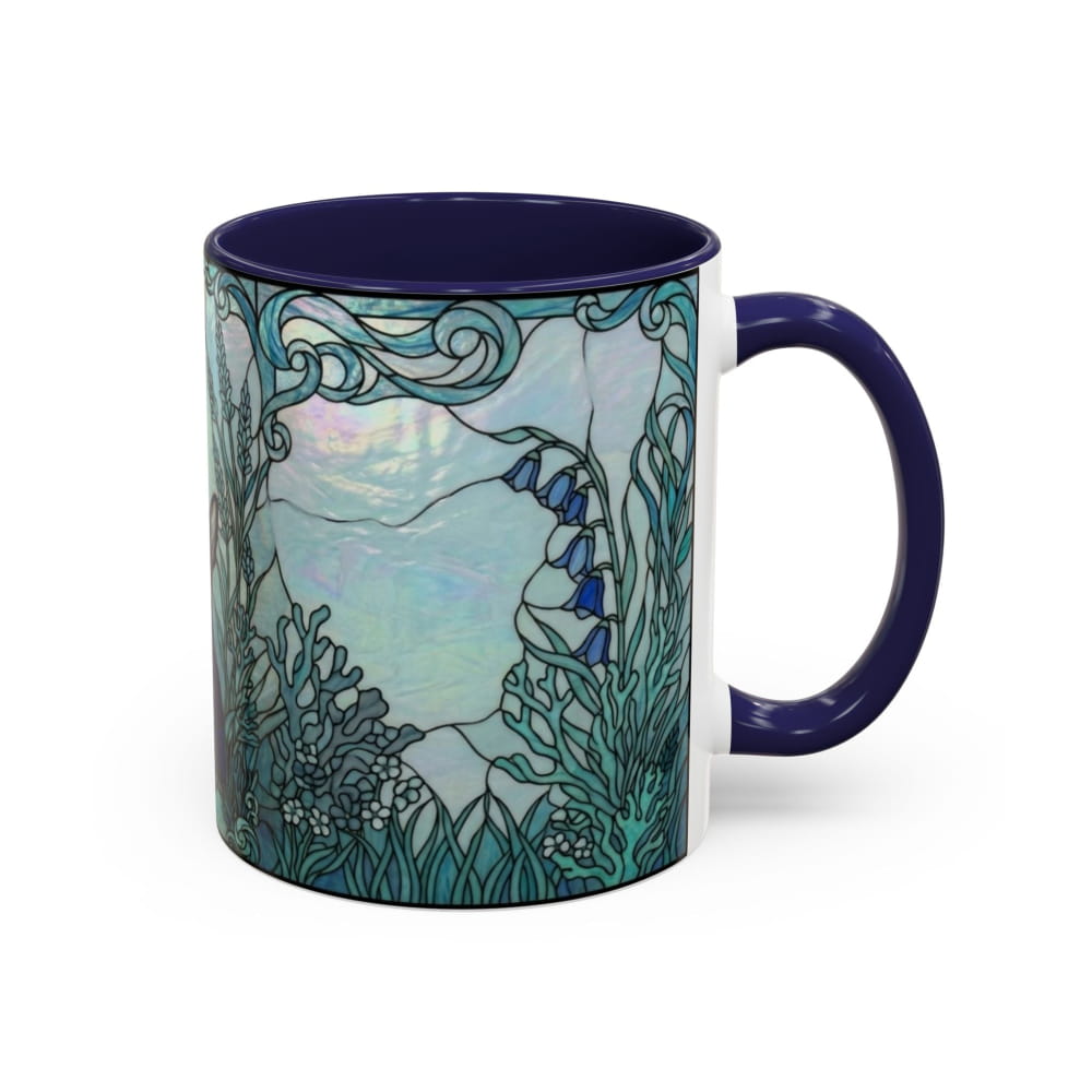 A ceramic mug featuring a stained-glass style illustration of an underwater scene with blue bellflowers, coral, and sea plants in shades of teal, blue, and white, with a dark navy blue handle and interior.
