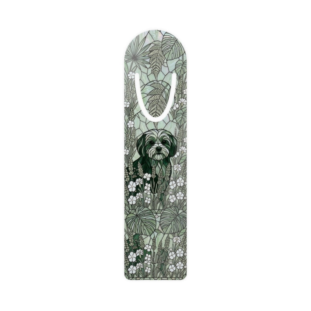 A tall, narrow decorative gift bag with a white handle, featuring an illustrated design of a black Shih Tzu dog surrounded by green tropical leaves and small white flowers on a pale sage green background.